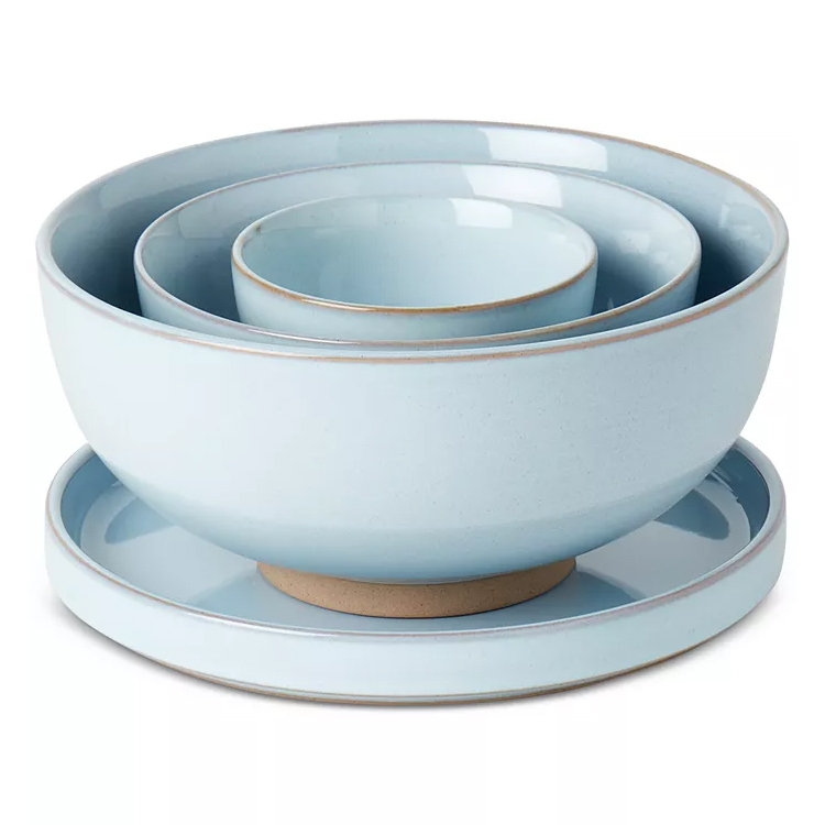 A light blue 4-piece stoneware nesting bowl set with a minimalist design, featuring three nested bowls of varying sizes and a matching plate at the base, ideal for serving or kitchen use.