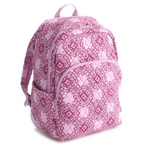 A pink quilted backpack featuring a floral and geometric pattern. It has multiple zippered compartments and side pockets.