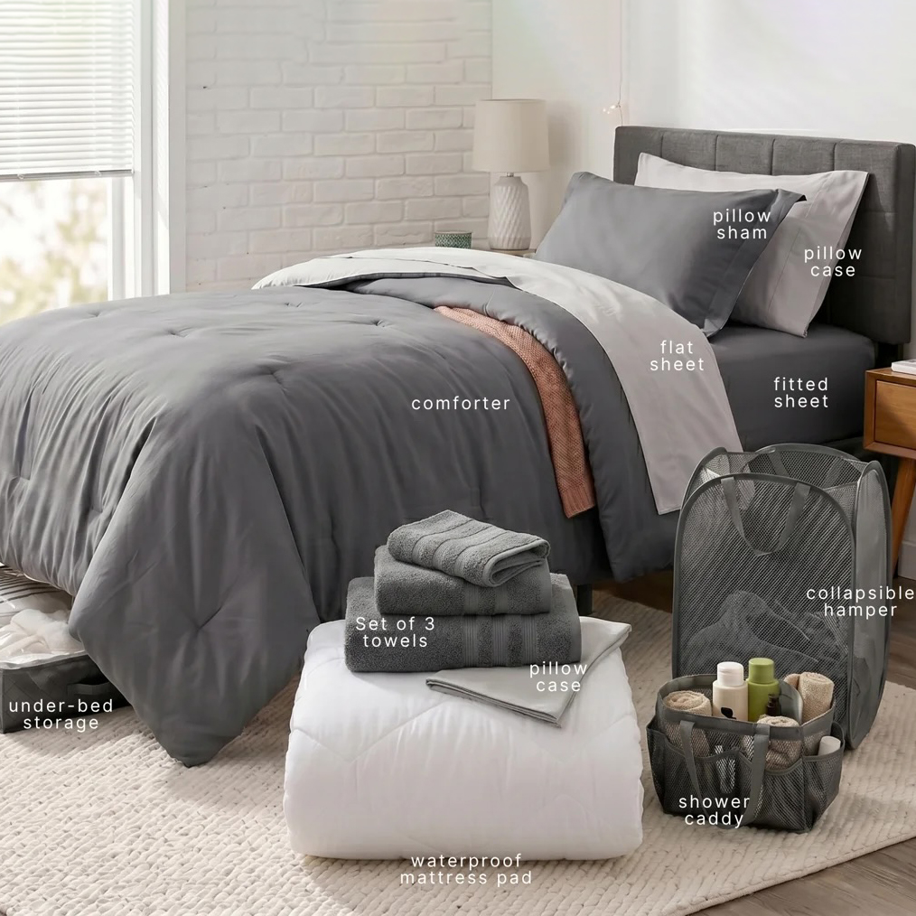 The image shows a neatly arranged bed with a comforter, flat and fitted sheets, pillowcases, a pillow sham, under-bed storage, a collapsible hamper, a shower caddy, a waterproof mattress pad, and a set of three towels.