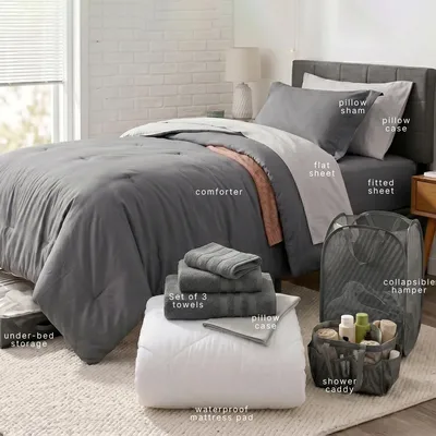 The image shows a neatly arranged bed with a comforter, flat and fitted sheets, pillowcases, a pillow sham, under-bed storage, a collapsible hamper, a shower caddy, a waterproof mattress pad, and a set of three towels.