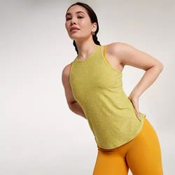 A woman is wearing a yellow sleeveless top and mustard leggings.