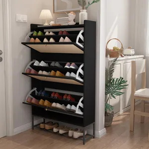 A black shoe rack with multiple tilt-out compartments displays various shoes. It's placed in a well-lit entryway, accompanied by decorative items like a lamp and plant.