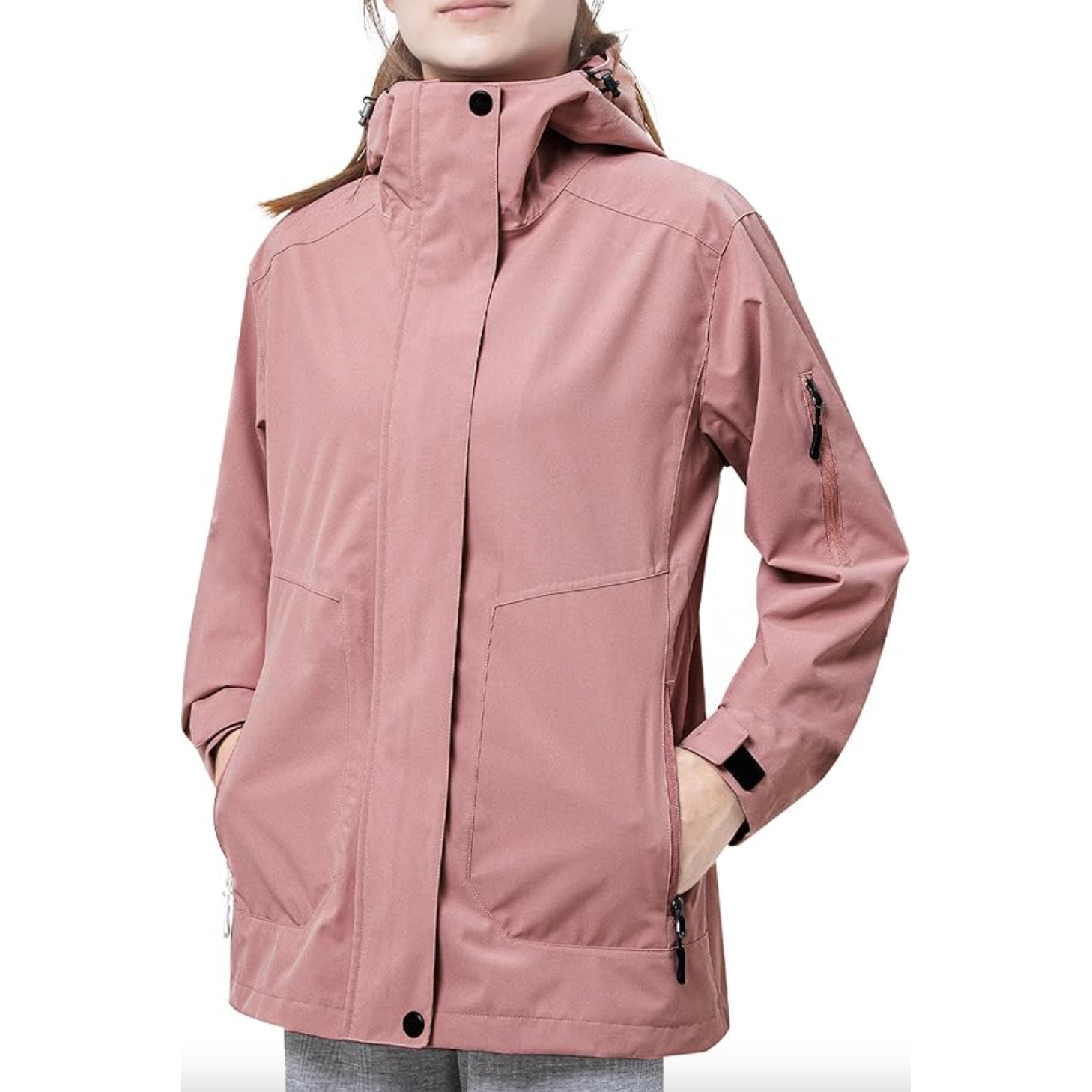 A person wearing a rose-colored jacket with a high collar, zippered pockets, and adjustable sleeve cuffs.