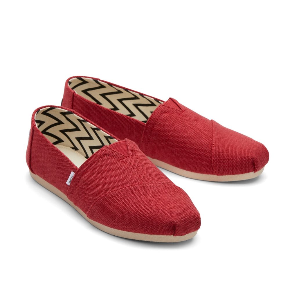 Red slip-on canvas shoes with a zigzag pattern inside and beige rubber soles.