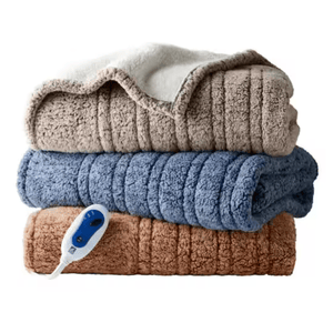 Three stacked, plush electric blankets in beige, blue, and brown, with a visible control remote.