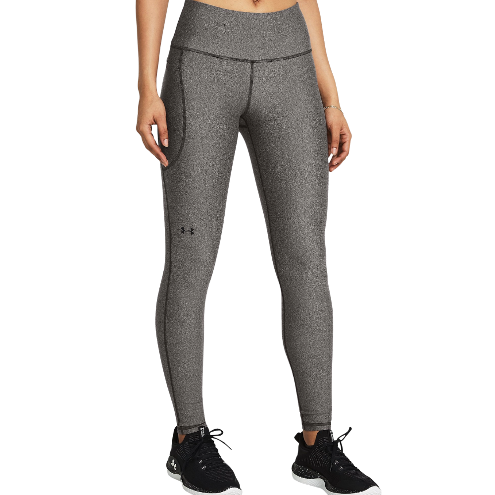 Grey Under Armour leggings with logo detailing, featuring a high waist and athletic fit, paired with black and white sneakers.