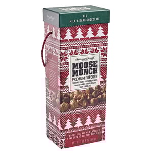 Harry & David Moose Munch Premium Popcorn features caramel-coated popcorn and nuts covered in milk chocolate and dark chocolate. The package contains two 10 oz bags, one of each chocolate type, and has a festive red design with white trees.