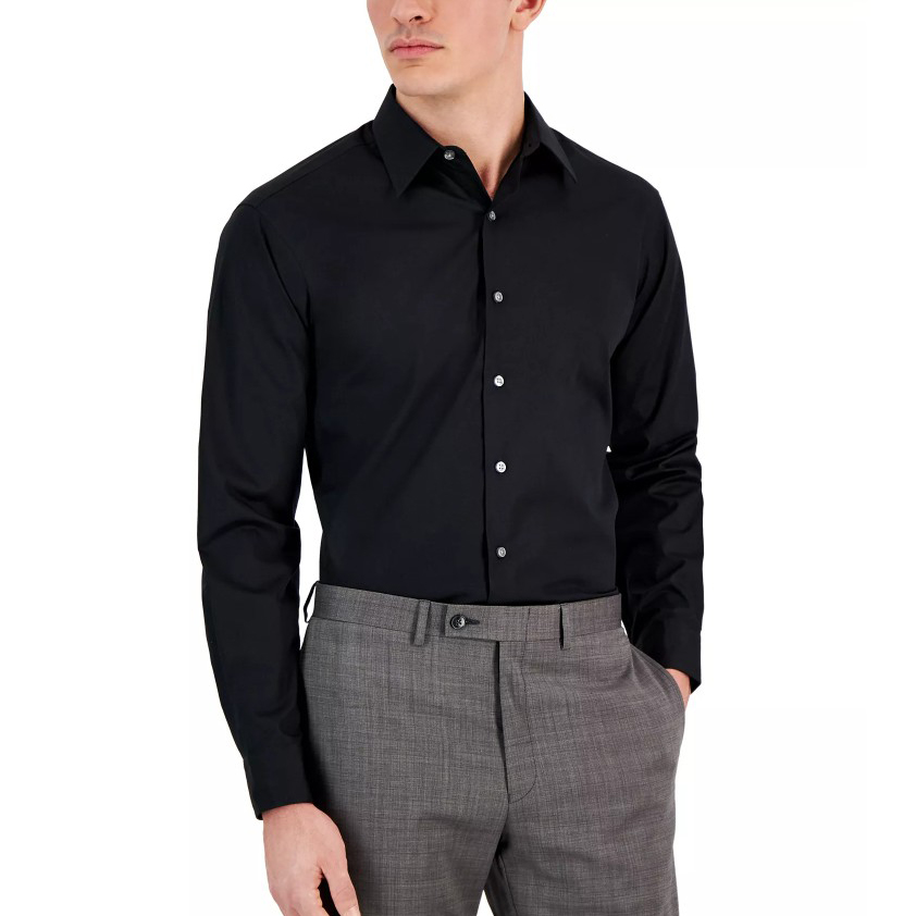 A man is wearing a black long-sleeve button-up shirt paired with gray dress pants.