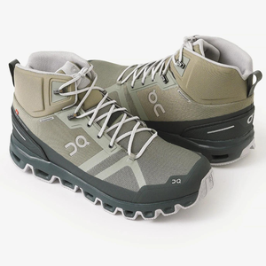 A pair of olive green and gray hiking boots with laces.