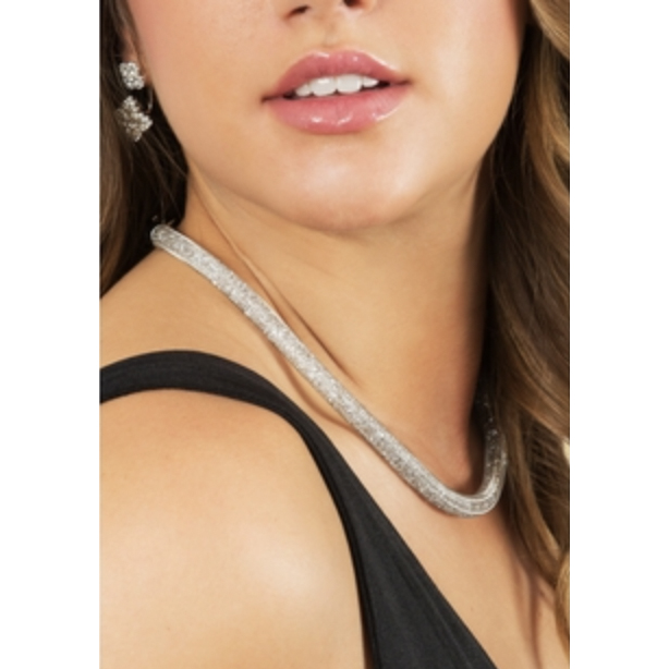 A woman with long hair is wearing a sparkling necklace and earrings, both featuring a rhinestone design, along with a black sleeveless top.