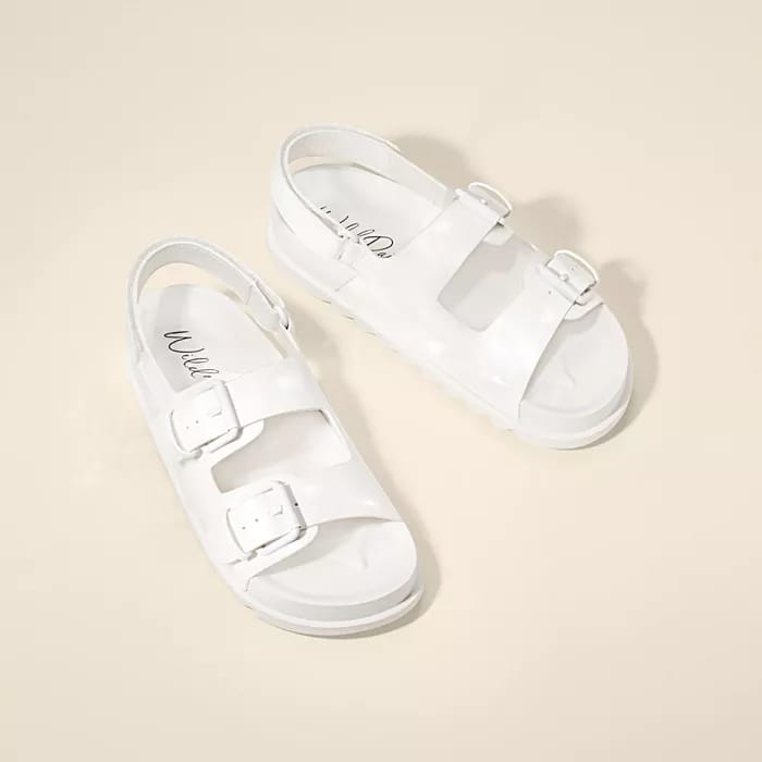 A pair of white, flat sandals with two adjustable buckles on each, and branding on the inner sole.