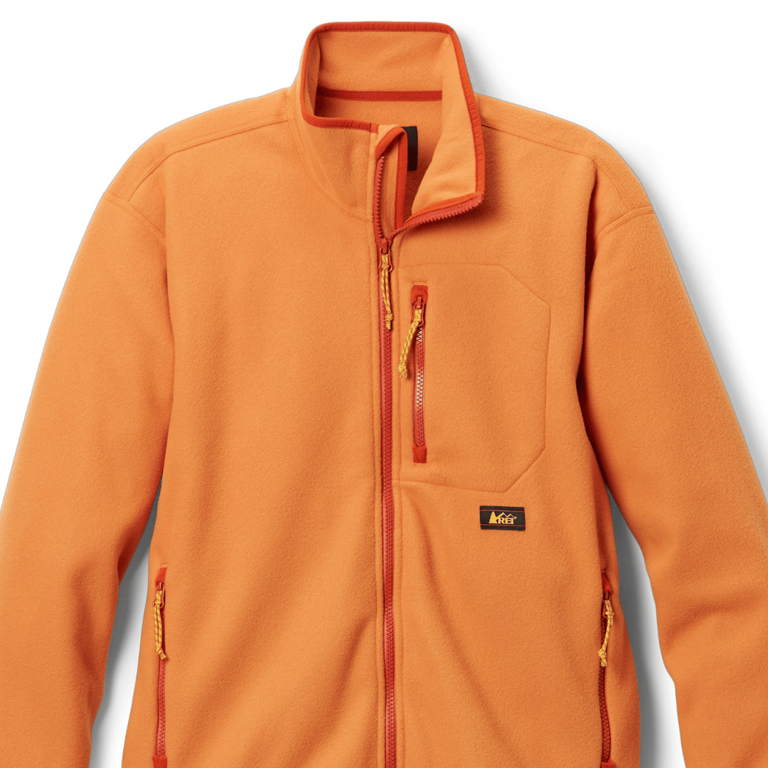 Orange fleece jacket with a high collar and yellow zippers.