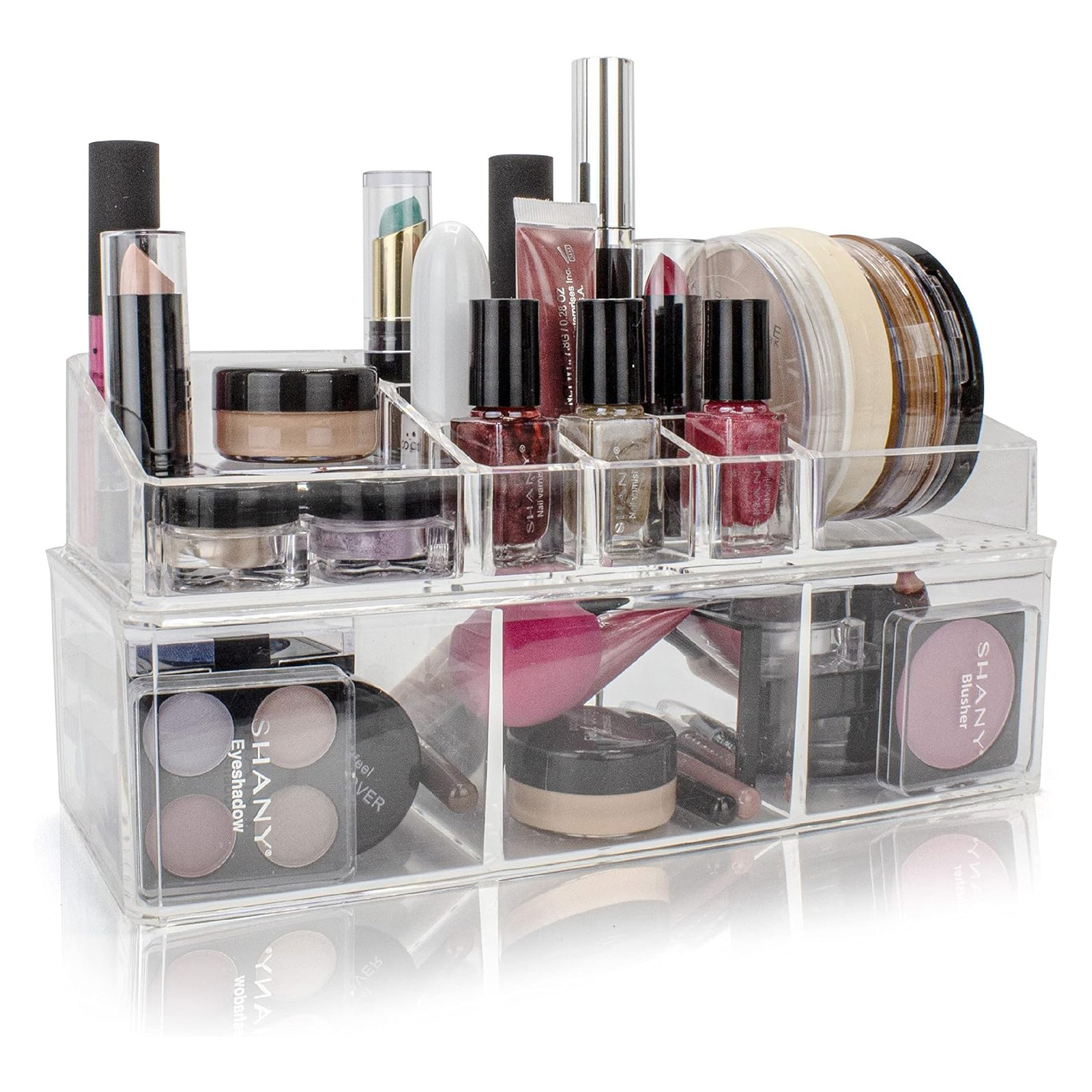 Clear acrylic makeup organizer with compartments holding lipsticks, nail polishes, eyeshadow palettes, lip gloss, foundation jars, and blush.