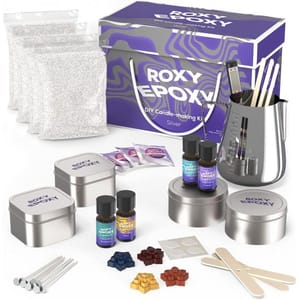 The kit includes wax pellets, fragrances, a melting pot, wicks, stirring sticks, dye blocks, and tin containers for candle-making.