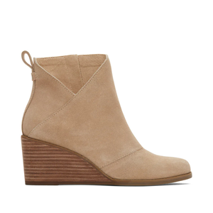 Beige suede ankle booties with a stacked wedge heel and a pull tab at the back for easy wear.