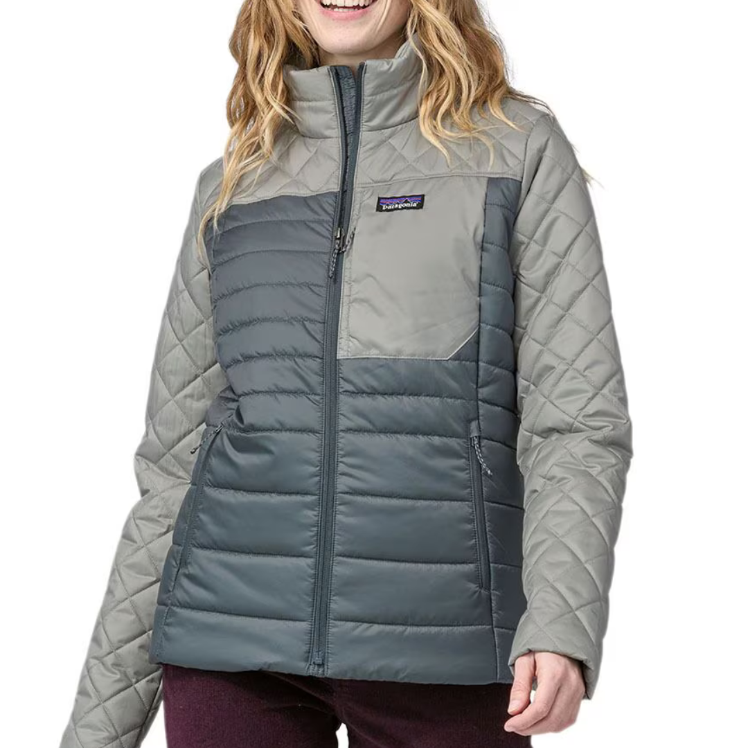 A woman is wearing a two-tone quilted jacket with a high collar and a Patagonia logo on the chest.