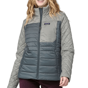 A woman is wearing a two-tone quilted jacket with a high collar and a Patagonia logo on the chest.