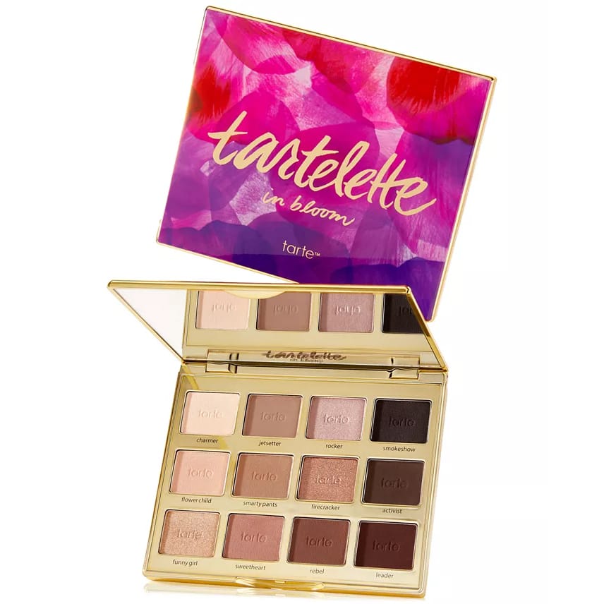 Tarte Tartelette In Bloom is an eyeshadow palette featuring 12 versatile matte and shimmer shades in warm, neutral tones, ideal for creating various eye looks. The packaging has a colorful floral design.