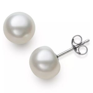 A pair of white pearl stud earrings with silver posts and butterfly backs.
