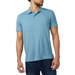 A man is wearing a light blue polo shirt paired with dark blue jeans.