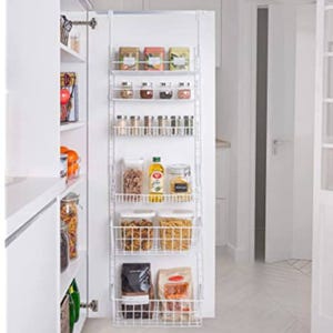 A pantry door organizer displays spices, canned goods, cooking oil, pasta, and other dry ingredients in wire baskets for efficient kitchen storage.