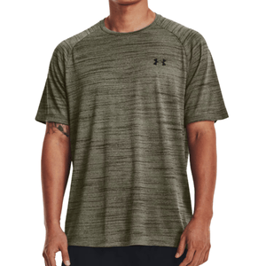 A man wears an olive green Under Armour short-sleeve performance t-shirt with a subtle heathered texture and a small logo on the chest.
