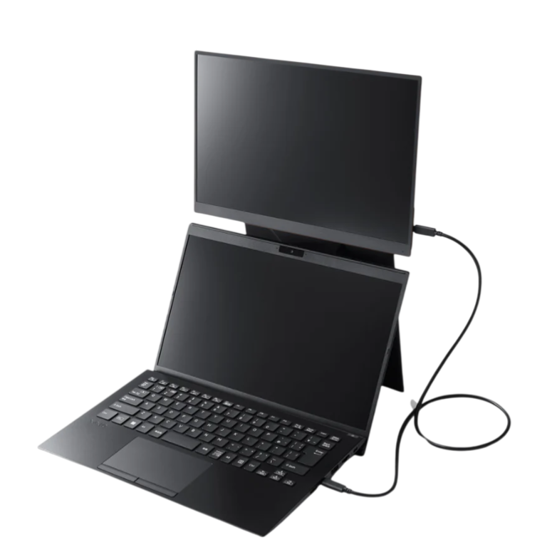 A compact, dual-screen laptop setup with an external monitor connected via a cable, positioned above the laptop.