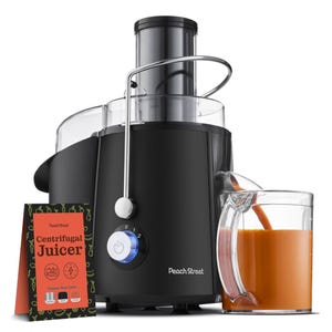A black Peach Street Centrifugal Juicer with a control dial and spout for dispensing juice into a glass container. Includes a pamphlet that highlights it as a centrifugal juicer and offers color options.