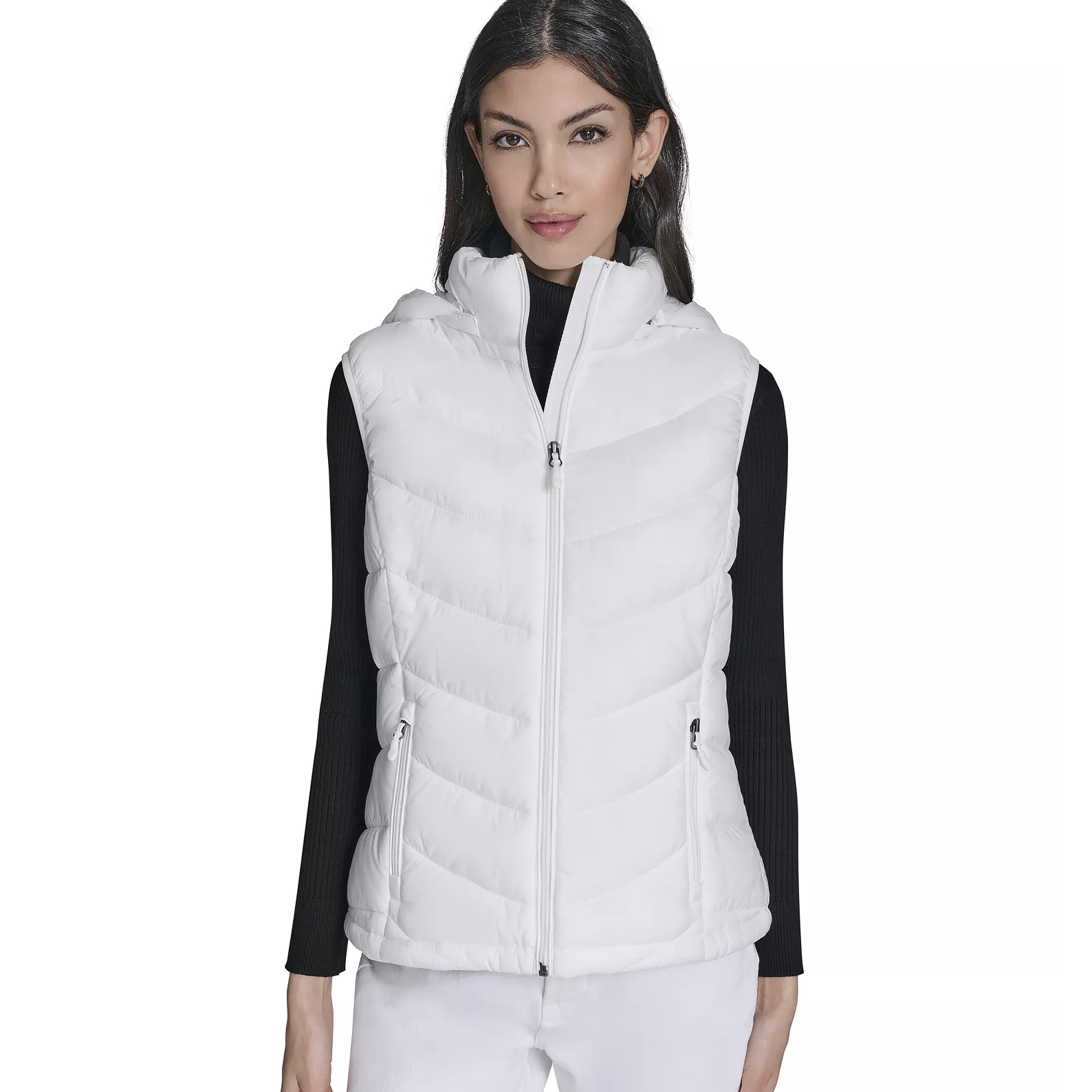 White puffer vest with a front zipper and zippered side pockets, worn over a black long-sleeve top.