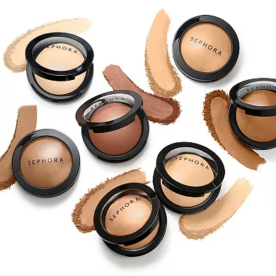 Assortment of Sephora brand powder foundations in various shades, displayed openly with smears illustrating color and texture.