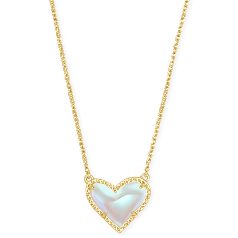 A gold chain necklace featuring a heart-shaped pendant with an iridescent stone, bordered by a gold frame. The design is simple and elegant.