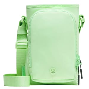 A light green crossbody bag with a front zipper pocket, adjustable strap, and a small logo at the bottom.