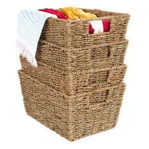 Stack of three woven storage baskets with integrated handles, one filled with colorful folded blankets and a towel draped over the top.