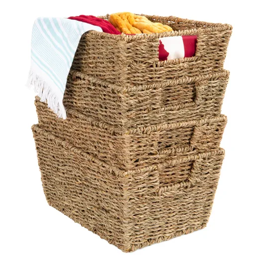 Stack of three woven storage baskets with integrated handles, one filled with colorful folded blankets and a towel draped over the top.