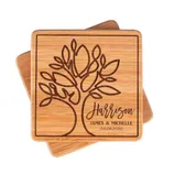 Two wooden coasters with an engraved tree design, personalized with the name \“Harrison,\“ the names \“James & Michelle,\“ and the date \“04.08.2020.\“