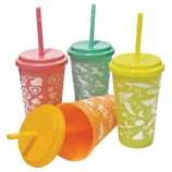 Colorful reusable cups with lids and straws in pink, green, yellow, and orange, featuring playful white patterns like hearts, animals, and ocean motifs.