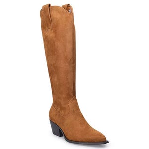 A brown suede knee-high boot with a pointed toe and a low stacked heel, featuring pull tabs on both sides.