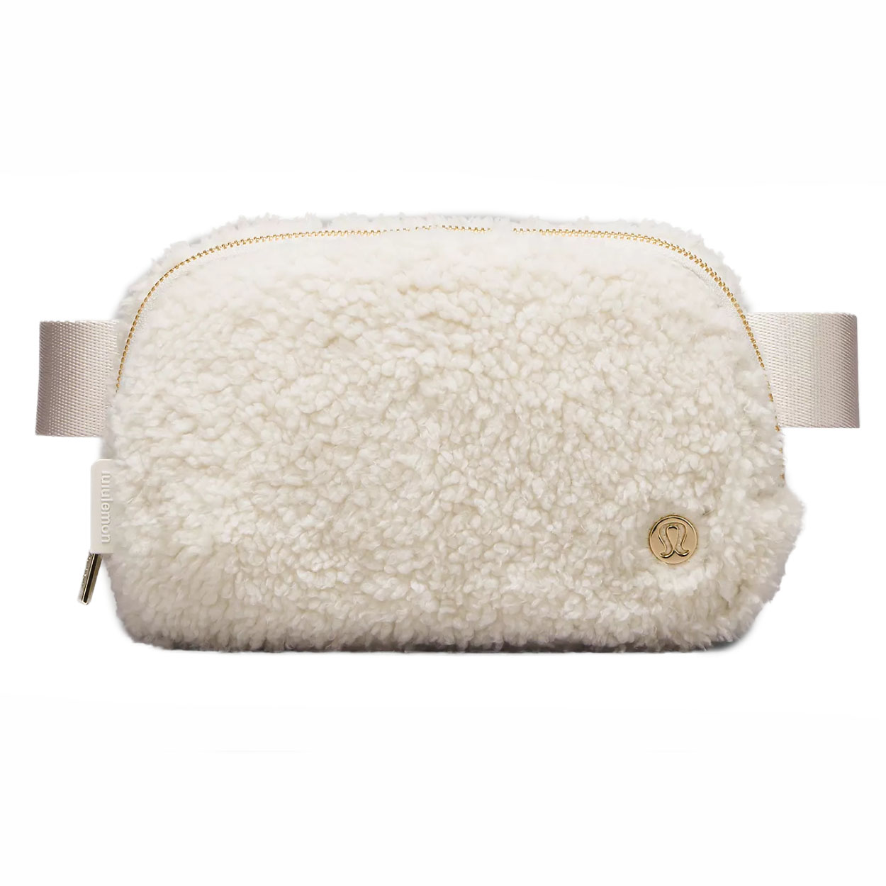 Lululemon fleece belt bag in cream features a soft, textured fabric with a zippered closure and adjustable strap. It has a small gold logo detail on one side.
