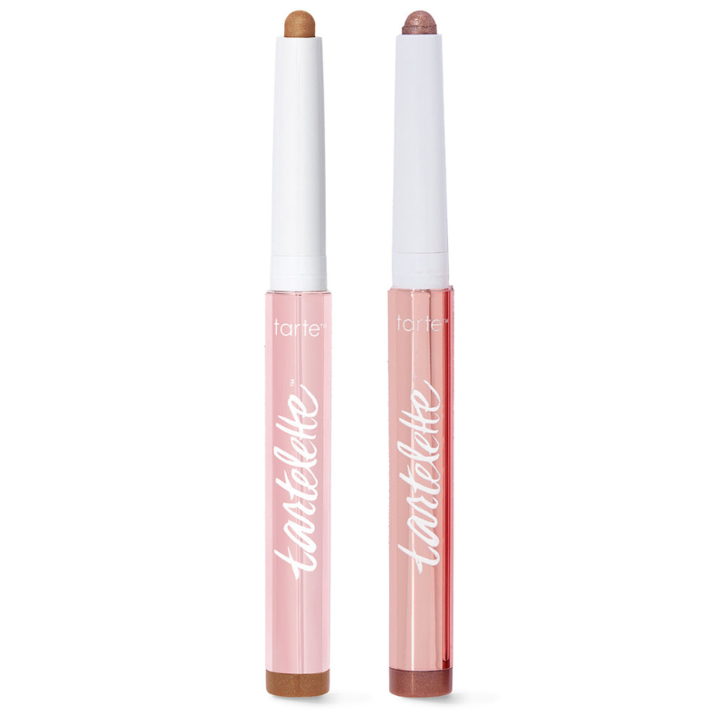 Two Tartelette retractable eyeshadow sticks with pink packaging, featuring light brown and pinkish-brown shades.