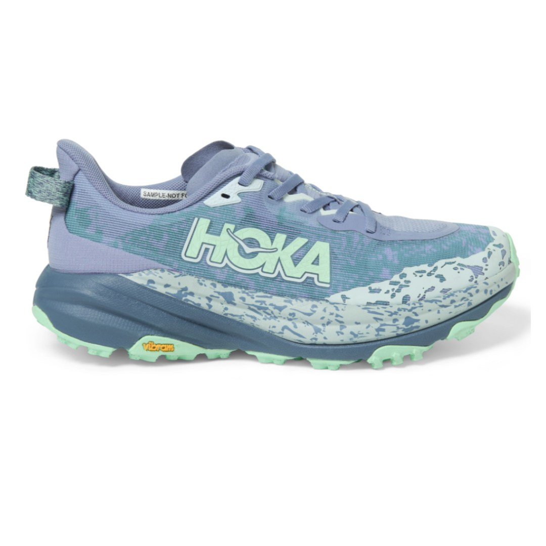 Hoka trail running shoe in lavender and mint green with a Vibram sole and a patterned midsole.