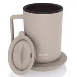 A beige mug with a handle, matching lid, and saucer, branded with \“purée\“ and red dots, likely designed for keeping beverages warm.