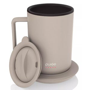 A beige mug with a handle, matching lid, and saucer, branded with \“purée\“ and red dots, likely designed for keeping beverages warm.