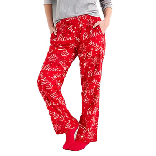 Red pajama pants with a festive \“believe\“ print and snowflake design, paired with a gray top.