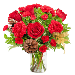A bouquet of red roses and carnations in a clear vase, complemented by pinecones, greenery, and a gold ribbon.