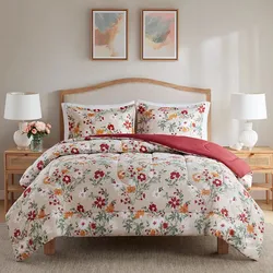 Floral-patterned bedding set on a wooden bed with two matching pillows, accompanied by two white table lamps on side tables, all under two abstract paintings on the wall.