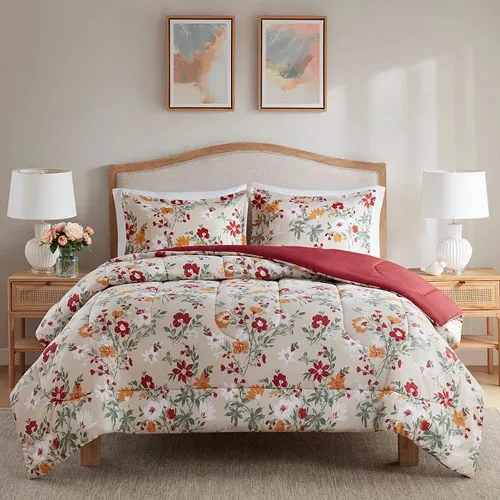Floral-patterned bedding set on a wooden bed with two matching pillows, accompanied by two white table lamps on side tables, all under two abstract paintings on the wall.