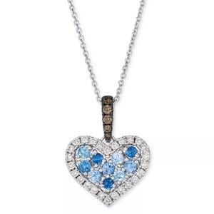 Heart-shaped pendant necklace with blue and white gemstones, set in silver; features a chain and a pavé gemstone bail.