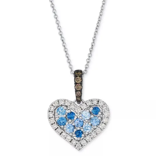 Heart-shaped pendant necklace with blue and white gemstones, set in silver; features a chain and a pavé gemstone bail.