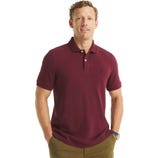 A man is wearing a maroon short-sleeve polo shirt with a small embroidered logo on the chest and olive green pants.