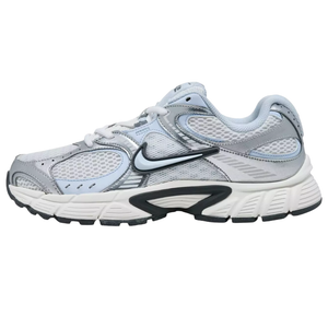 A light gray and white Nike running shoe featuring mesh panels, synthetic overlays, and a prominent black swoosh. The sole is chunky with detailed patterns for traction.